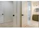 Hallway with white doors and black hardware, leading to the bathroom with stylish green vanity at 3300 Travis Nw Ln, Concord, NC 28027