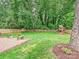 Spacious backyard with lush lawn, a brick patio, a wooden fence and a play structure at 3610 Mill Pond Rd, Charlotte, NC 28226
