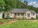 Charming single-story home with a welcoming front porch, landscaped yard, and mature trees at 3610 Mill Pond Rd, Charlotte, NC 28226