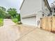 Exterior shot of a two-car garage, spacious driveway and backyard fence on a cloudy day at 3610 Mill Pond Rd, Charlotte, NC 28226