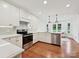 Well-lit kitchen featuring white cabinetry, stainless steel appliances, and hardwood floors at 3610 Mill Pond Rd, Charlotte, NC 28226