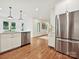 Stainless steel appliances and white cabinets in a modern kitchen with hardwood flooring and natural light at 3610 Mill Pond Rd, Charlotte, NC 28226