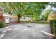 Large backyard with a concrete patio, mature trees, and a quaint wooden fence at 415 Princeton Dr, Salisbury, NC 28144