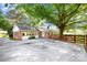 Well-maintained brick home featuring a large concrete patio and charming wooden fence at 415 Princeton Dr, Salisbury, NC 28144