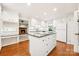 Spacious kitchen with an island, white cabinets, and hardwood floors, with a fireplace visible in the background at 415 Princeton Dr, Salisbury, NC 28144