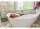 Close-up of a luxurious soaking tub, glass shower, and elegant marble tile in bright bathroom at 424 Preston Rd, Mooresville, NC 28117