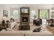 Bright living room featuring a stone fireplace and a seamless transition to the outdoor deck at 424 Preston Rd, Mooresville, NC 28117