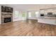 Open-concept living room with a stone fireplace, hardwood floors, and a sliding glass door to the backyard at 424 Preston Rd, Mooresville, NC 28117