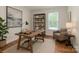 Home office provides natural light with a large desk, chair, and bookcase at 424 Preston Rd, Mooresville, NC 28117