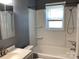 This clean bathroom has a shower-tub combo and vanity sink with a framed mirror above the sink at 4630 Roberta Rd, Concord, NC 28027