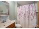 Bathroom with white fixtures, floral shower curtain, and vanity with storage at 480 S Ingleside Farm Rd, Iron Station, NC 28080