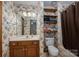 Quaint bathroom features floral wallpaper, wooden shelving, and shower-tub combo at 480 S Ingleside Farm Rd, Iron Station, NC 28080