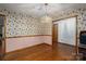 Traditional dining room with hardwood floors and charming wallpaper, illuminated by a stylish chandelier at 480 S Ingleside Farm Rd, Iron Station, NC 28080