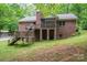 Backyard with deck, screened porch, steps and brick wall on a sloped lot at 480 S Ingleside Farm Rd, Iron Station, NC 28080