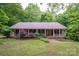 Charming single-story home with a covered porch and lush greenery creating a private, serene setting at 480 S Ingleside Farm Rd, Iron Station, NC 28080