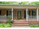 Inviting front porch featuring brick steps, white columns, and space for seating, perfect for relaxing outdoors at 480 S Ingleside Farm Rd, Iron Station, NC 28080
