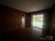 Bedroom featuring wood paneled walls, sliding glass door access to the backyard at 4817 Ridgeley Dr, Charlotte, NC 28208