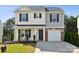 Charming two-story home featuring a covered front porch, neutral siding, and an attached garage with a stone facade at 509 Ellingsworth Ln, Charlotte, NC 28214