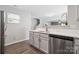 Well-lit kitchen featuring stainless steel dishwasher, white cabinets, and modern finishes at 509 Ellingsworth Ln, Charlotte, NC 28214