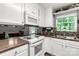 Well-lit kitchen showcasing white cabinets, modern appliances, and dark countertop space, great for cooking at 522 Kittiewake Ln, Clover, SC 29710