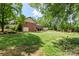 Expansive backyard featuring lush lawn, mature trees, brick home and shed at 530 Bonita Dr, Landis, NC 28088