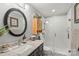 Modern bathroom featuring a glass-enclosed shower, granite vanity and round mirror at 530 Bonita Dr, Landis, NC 28088