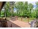 Outdoor deck with a table and chairs, railing, and view of backyard and green lush trees at 530 Bonita Dr, Landis, NC 28088