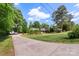 View of paved driveway leading to brick home with mature trees in yard at 530 Bonita Dr, Landis, NC 28088