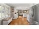 Bright open-concept kitchen featuring white cabinets, hardwood floors, stainless steel appliances, and a seamless flow to the living area at 530 Bonita Dr, Landis, NC 28088