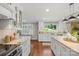 Bright open kitchen with white cabinets, granite countertops, stainless steel appliances, and a view of the backyard at 530 Bonita Dr, Landis, NC 28088