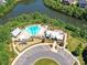 Aerial view showcasing an amenity center with a pool, playground, and parking adjacent to a picturesque lake at 5420 Meadowcroft Way, Fort Mill, SC 29708