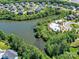 Aerial view showcasing a pool and amenity center by a lake, surrounded by trees in a residential community at 5420 Meadowcroft Way, Fort Mill, SC 29708