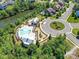 Aerial view of an amenity center, featuring a large pool, playground, and parking, nestled by a scenic lake at 5420 Meadowcroft Way, Fort Mill, SC 29708