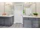 Bathroom featuring dual vanities with quartz countertops, modern lighting, and wood-look tile flooring at 5420 Meadowcroft Way, Fort Mill, SC 29708