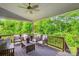Relaxing covered deck with comfortable seating overlooking lush greenery at 5420 Meadowcroft Way, Fort Mill, SC 29708