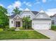 Charming home exterior featuring stone accents, a well-manicured lawn, and an attached garage at 5420 Meadowcroft Way, Fort Mill, SC 29708