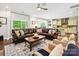 Open-concept living room boasts a sectional sofa, patterned rug, and seamless flow to the kitchen area at 5420 Meadowcroft Way, Fort Mill, SC 29708