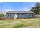 The back of this beautiful home showcases classic blue siding, a well manicured lawn, and brick crawl space foundation at 5528 Little Mountain Rd, Gastonia, NC 28056