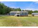 Expansive lawn complements this stylish blue home with white trim, featuring a welcoming front porch and classic charm at 5528 Little Mountain Rd, Gastonia, NC 28056