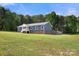 Side angle of a stunning blue home with a spacious lawn and a quaint porch offers picturesque outdoor living at 5528 Little Mountain Rd, Gastonia, NC 28056