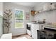 Bright laundry room features wood floors, window, white washer and dryer set, shelving, and modern design at 5528 Little Mountain Rd, Gastonia, NC 28056