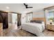Bright main bedroom featuring a ceiling fan, wood floors, and ensuite bathroom with barn door at 5528 Little Mountain Rd, Gastonia, NC 28056