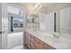 Bright bathroom featuring a double vanity, a large mirror, and an open doorway leading to the bedroom at 5940 Four Wood Dr, Matthews, NC 28104