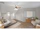 Spacious bedroom with wood-look floors, a ceiling fan, and a cozy seating area with natural light at 5940 Four Wood Dr, Matthews, NC 28104