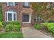 Charming brick home featuring an arched entryway, bay window, and mature landscaping at 5940 Four Wood Dr, Matthews, NC 28104