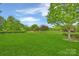 Scenic view of the golf course with lush green grass and mature trees on a sunny day at 5940 Four Wood Dr, Matthews, NC 28104
