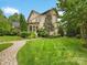 Spacious backyard featuring lush green lawn, manicured landscaping, and a charming screened-in porch at 601 Dorothy Dr, Charlotte, NC 28203