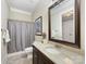 Neutral bathroom featuring a granite countertop, framed mirror, and a shower-tub combination at 601 Dorothy Dr, Charlotte, NC 28203