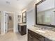 Bathroom featuring dark wood cabinets, granite countertop, and a door leading to the water closet at 601 Dorothy Dr, Charlotte, NC 28203