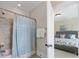 Bright bathroom features a shower with tile surround, a shower curtain, and access to the main bedroom at 601 Dorothy Dr, Charlotte, NC 28203
